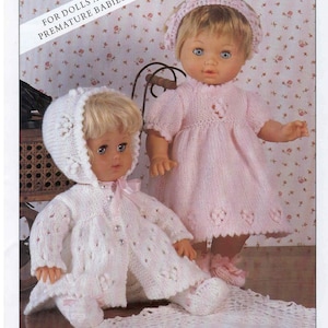 May include: Two knitted doll outfits, one pink and one white, with lace detailing. The outfits are for dolls and premature babies. The text "FOR DOLLS AND PREMATURE BABIES" is visible in the image.