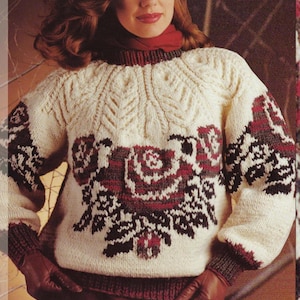 Op de afbeelding: Crèmekleurige gebreide trui met een bloemenontwerp in bordeauxrood, zwart en bruin. De trui heeft een geribbelde kraag, manchetten en zoom. De mouwen zijn lang en de stijl is een klassieke, gezellige knitwear.