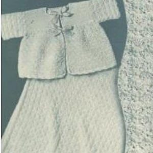 May include: A white crocheted baby outfit set including a bonnet, a cardigan, a skirt, and a blanket.