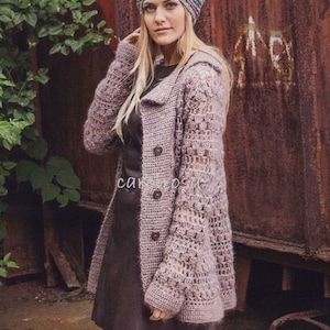 May include: A light purple, open-weave crochet coat with a hood and three brown buttons. The coat is worn over a dark dress and paired with a striped beanie. The background features a rusty metal wall and green foliage.