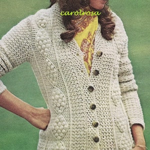 May include: A white knitted cardigan with a button-up front and a textured design. The cardigan has a V-neck and long sleeves.