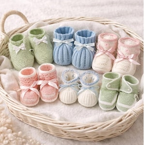 May include: A collection of handmade baby booties in a woven basket. The booties are in various pastel colors, including green, blue, pink, and white, each adorned with a satin bow. The knitted texture and soft colors suggest a baby shower or newborn gift.