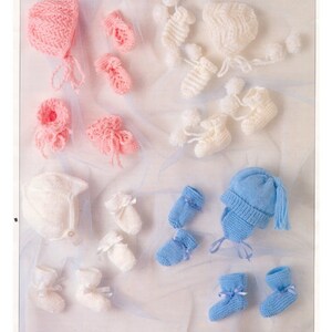May include: A knitting pattern for a baby hat and booties in pink, white, and blue. The pattern is called "Double Knit" and the pattern number is 00738.