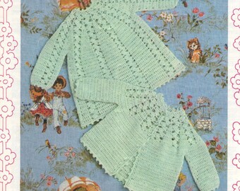 May include: Two crocheted baby sweaters in a light green color. The sweaters have a lacy pattern and are laid out on a blue and white floral background.
