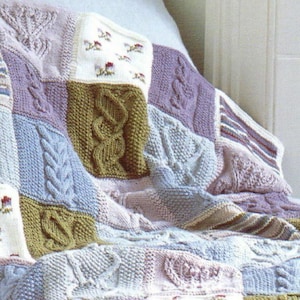 May include: A knitted patchwork blanket with various textures and colors, including light blue, green, pink, and white.