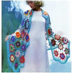 Peut inclure: Un châle en crochet avec un motif floral dans des tons de bleu, rose, orange, jaune et vert. Le châle est réalisé avec un point ajouré délicat et présente une variété de formes de fleurs.