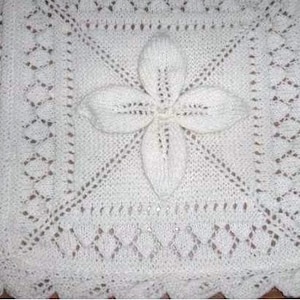 May include: White crocheted baby blanket with a delicate floral design in the center.