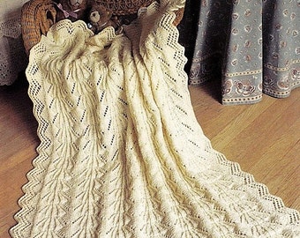 May include: A white crocheted baby blanket with a lacy pattern. The blanket is draped over a wicker chair with two teddy bears.
