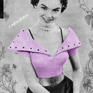 Peut inclure: Une femme portant un haut en tricot lavande avec un col large et pointu et des manches courtes. Le haut a une rangée de petits boutons noirs sur le devant et une ceinture noire autour de la taille. La femme porte un collier de perles et a un sourire sur le visage.