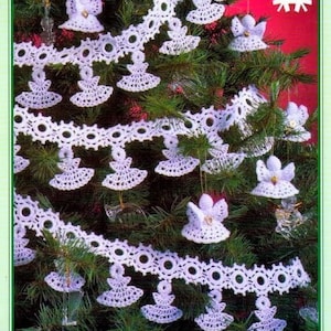 May include: White crocheted angel ornaments hanging from a white crocheted garland on a green Christmas tree. The garland is decorated with white crocheted circles. The text "White Christmas Collection" is visible in the upper right corner of the image.