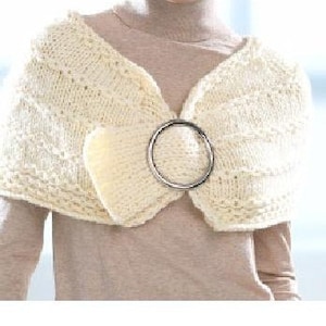 May include: A white knitted shawl with a large silver ring detail.