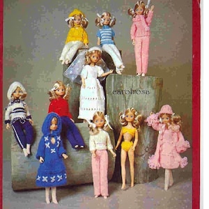 Puede incluir: Una colección de muñecas vintage vestidas con varios atuendos. Las muñecas visten ropa de varios colores, incluyendo amarillo, azul, rosa y blanco. El texto "carolrosa" es visible.