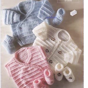Può includere: Una collezione di abbigliamento per neonati lavorato a maglia in morbidi colori pastello. L'immagine presenta un cardigan azzurro e scarpine abbinate, un cardigan bianco con dettagli floreali e scarpine, e un cardigan rosa con scarpine. Il testo recita "Includes sizes for premature babies or dolls."