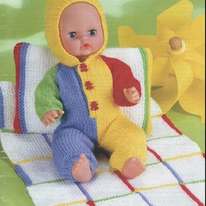 May include: A knitted doll outfit with a yellow, green, blue, and red color scheme. The outfit includes a hooded jumpsuit and a matching blanket. The doll is wearing the outfit and sitting on the blanket.