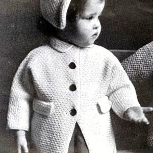 Puede incluir: Un abrigo blanco de punto con un gorro blanco de punto. El abrigo tiene cuello, botones y bolsillos. El gorro tiene un borde.