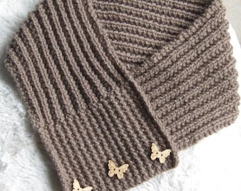 May include: A brown knitted infinity scarf with a ribbed texture and four wooden butterfly buttons.