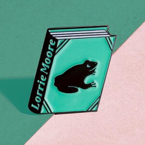 Vem ska driva grodsjukhuset av E. Lorrie Moore Emaljnål - Badge - Bokälskare - Läsargåva - Gåva till bokälskare - Bokgåva -