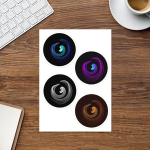 May include: A sheet of four circular stickers featuring abstract spiral designs. Each sticker displays a unique colour gradient: one blue, one purple, one white, and one orange, all set against a dark circular background with a white border.