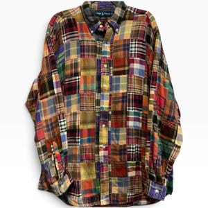 May include: A long-sleeve button-down shirt featuring a multi-coloured patchwork design with various plaid and check patterns in shades of red, blue, yellow, green, and brown. The shirt has a buttoned collar, a front button placket, and cuffs.