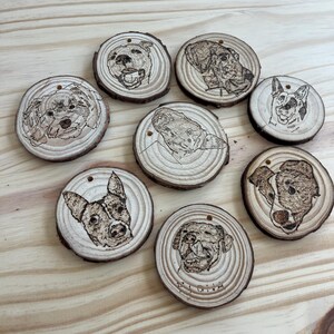 May include: Eight round wood slices with a burned image of a dog's face on each. The wood slices are approximately 3 inches in diameter.