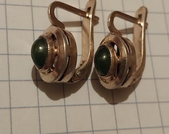 Può includere: Un paio di orecchini a cerchio d'argento con accenti di pietre preziose verdi. Gli orecchini hanno un design delicato e intricato.