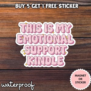 May include: A pink and white sticker with the text "THIS IS MY EMOTIONAL SUPPORT KINDLE". The sticker also says "waterproof" and "MAGNET OR STICKER". The sticker has a white border and yellow star accents.