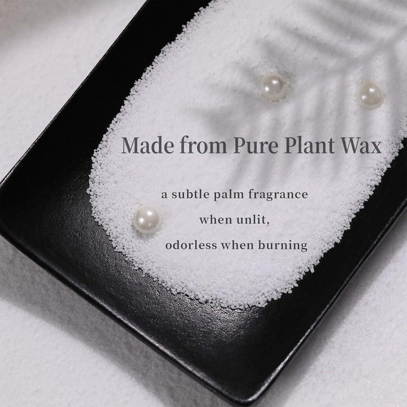 Puede incluir: Perlas de cera blanca en un plato negro. El texto "Made from Pure Plant Wax" est&aacute; impreso en la imagen. El texto "a subtle palm fragrance when unlit, odorless when burning" tambi&eacute;n est&aacute; impreso en la imagen.