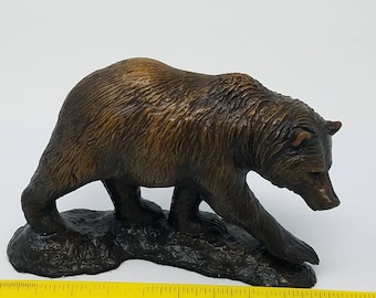 May include: A brown bear figurine walking on a rocky base. The bear is sculpted in a realistic style with detailed fur and a natural pose. The figurine is approximately 5 inches long.