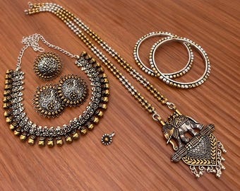 May include: An antique-style jewelry set featuring a necklace, earrings, a ring, and bracelets. The necklace has an elephant pendant. The jewelry is silver and gold-toned, with intricate detailing and a vintage aesthetic.