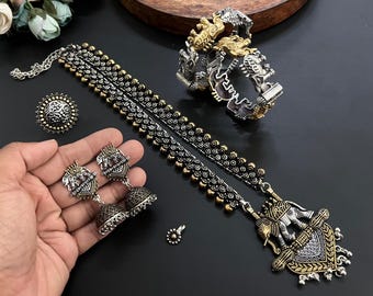 May include: An antique silver and gold-toned jewelry set featuring an elephant pendant necklace, matching earrings, a ring, and a bracelet. The set has intricate detailing and a vintage aesthetic, perfect for special occasions.