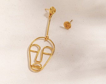 Gouden draad gezicht oorbellen, asymmetrische oorbellen, niet-overeenkomende oorbellen, asymmetrische statement oorbellen, Afrikaans masker oorbellen, tribale sieraden