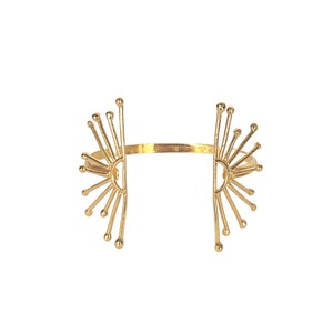 K&ouml;nnte beinhalten: Ein goldfarbenes Armband mit geometrischem Design, das zwei Sonnenstrahlenformen auf beiden Seiten des Bandes aufweist.