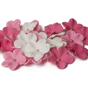 Peut inclure: Un ensemble de fleurs artificielles roses et blanches, chacune avec une petite perle argentée au centre. Les fleurs sont disposées en grappe lâche, parfaites pour l'artisanat ou la décoration.