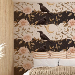May include: A bedroom with a decorative wall mural featuring black crows perched on branches, roses, and crescent moons. The bed has white linens, striped pillows, and a chunky knit blanket. A potted plant and a side table with a lamp are also visible.