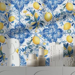 May include: A white cabinet with decorative items in front of a wallpaper with a lemon and blue floral pattern. The wallpaper features yellow lemons, blue leaves, and a white background.