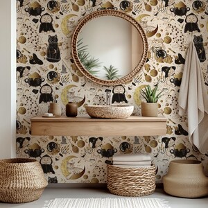 May include: A bathroom scene with patterned wallpaper featuring black cats, moons, and celestial motifs. A round woven mirror is above a stone sink and wooden shelf. Woven baskets and a plant complete the decor.