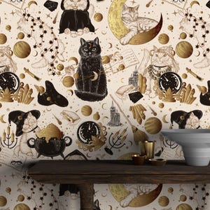 May include: A cream-coloured wallpaper with a repeating pattern of cats, moons, and stars in gold and black. The design incorporates mystical elements, with cats depicted in various poses alongside celestial and magical symbols.