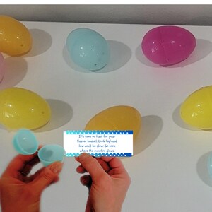 May include: A blue card with white polka dots and blue text that reads "It's time to hunt for your Easter basket. Look high and low don't be slow. Go look where the monitor glows."  The card is surrounded by colorful plastic Easter eggs.