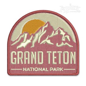 May include: Embroidered patch with a red background and a white outline. The patch features a white mountain range with a yellow sun setting behind it. The text "Grand Teton National Park" is written in white below the mountain range.
