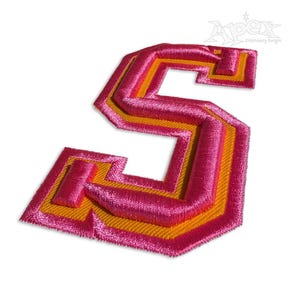 Peut inclure: Écusson brodé en forme de lettre "S" rose et orange. Le patch présente un design en couches, avec une couche extérieure rose et une couche intérieure orange. Idéal pour les vêtements ou les projets d'artisanat.