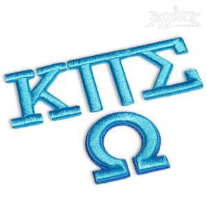 May include: Blue embroidered letters spelling out "KTT" and "Σ" with a blue embroidered omega symbol.