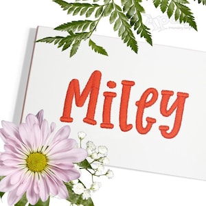 May include: Embroidered name "Miley" in a red cursive font on a white background.