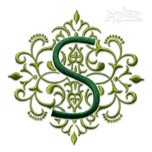 May include: Green embroidered monogram letter S with a decorative floral design.