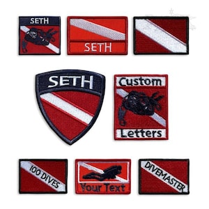 May include: A collection of embroidered patches in red, white, and black. The patches feature diving-related imagery, including a diver silhouette and the text "SETH", "CUSTOM LETTERS", "100 DIVES", "Your Text", and "DIVEMASTER".
