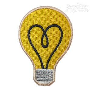 May include: Yellow embroidered light bulb patch with a black heart-shaped filament. The patch has a beige border and a gray and white base.