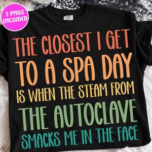 Könnte beinhalten: Ein schwarzes T-Shirt mit kurzen Ärmeln und mehrfarbigem Text: THE CLOSEST I GET TO A SPA DAY IS WHEN THE STEAM FROM THE AUTOCLAVE SMACKS ME IN THE FACE. Die Schrift ist in den Farben Orange, Gelb, Grün und Blaugrün gehalten.