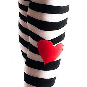 May include: Black and white striped leggings with a red heart applique on the knee. The leggings are made of a soft material and are suitable for various occasions. The image also includes the text "lane langmade's Wicked & Wonder".