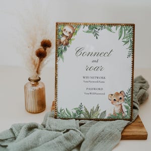 May include: A framed sign with the words "Connect and roar" and jungle-themed illustrations. The sign includes space for WiFi network name and password. A vase with dried flowers sits to the left.