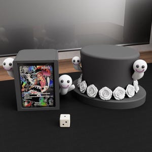 May include: A gray card holder and a black top hat with white roses, decorated with smiling ghost figures. A white die is on the black surface. The card holder displays a colorful card.