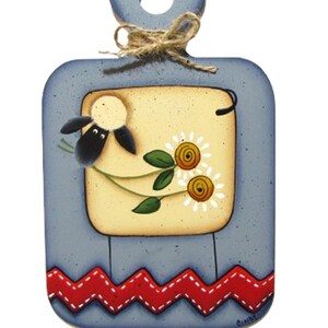 May include: A decorative wooden cutting board with a blue frame and a sheep illustration. The center features a yellow square with a sheep and daisies. A red zigzag pattern accents the bottom.